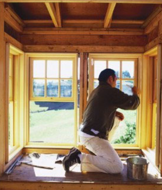 装修公司工人在给窗户上油漆 装修公司工人在给窗户上油漆